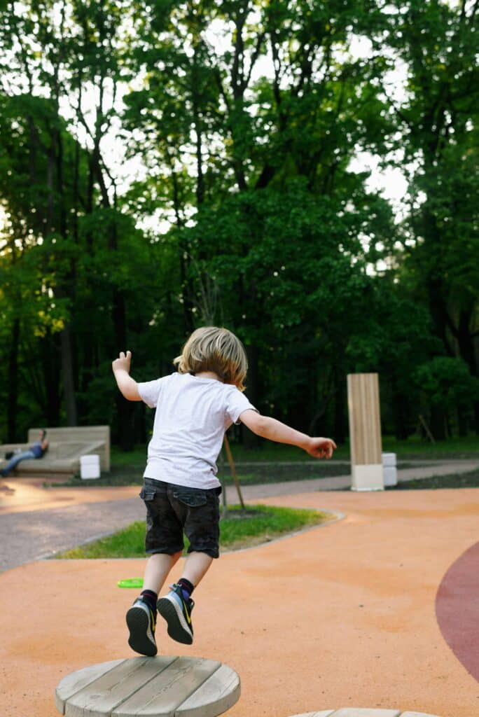 A carefree child leaps in a vibrant outdoor park setting