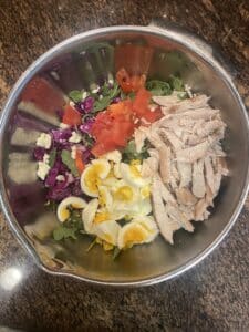 Spring mix salad with grilled chicken, hard boiled eggs, and vegetables, high protein nut free salad