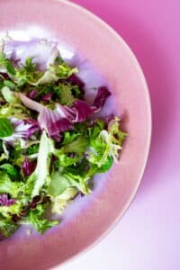 Spring mix salad greens in a bowl without protein, example of a light salad base
